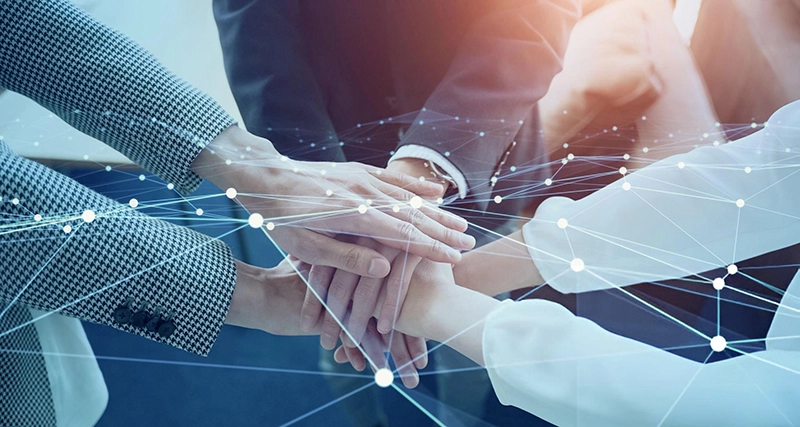 Team stacking hands with digital network overlay, symbolizing collaboration and trust built through MSPwiz assessment process.